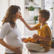 Boy feeds an orange to pregnant woman with gestational diabetes