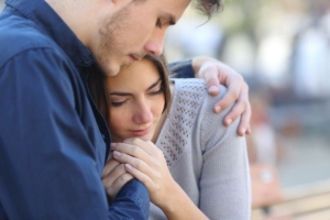 Couple hugging sad about multiple miscarriages