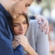 Couple hugging sad about multiple miscarriages