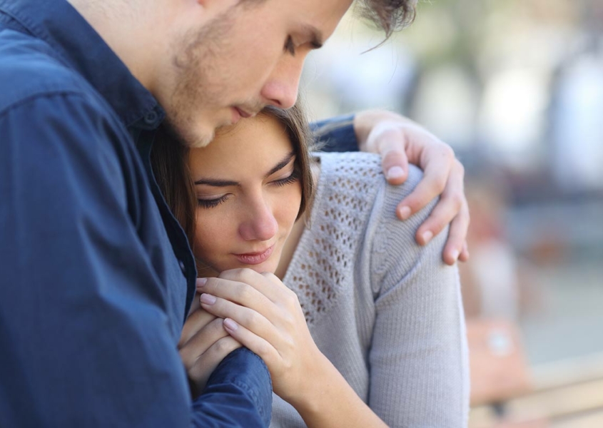 Couple hugging sad about multiple miscarriages