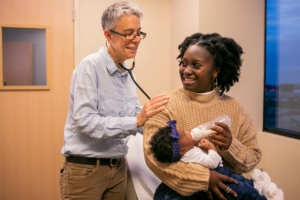 Smiling Madison Women's Health female OBGYN with patient and baby
