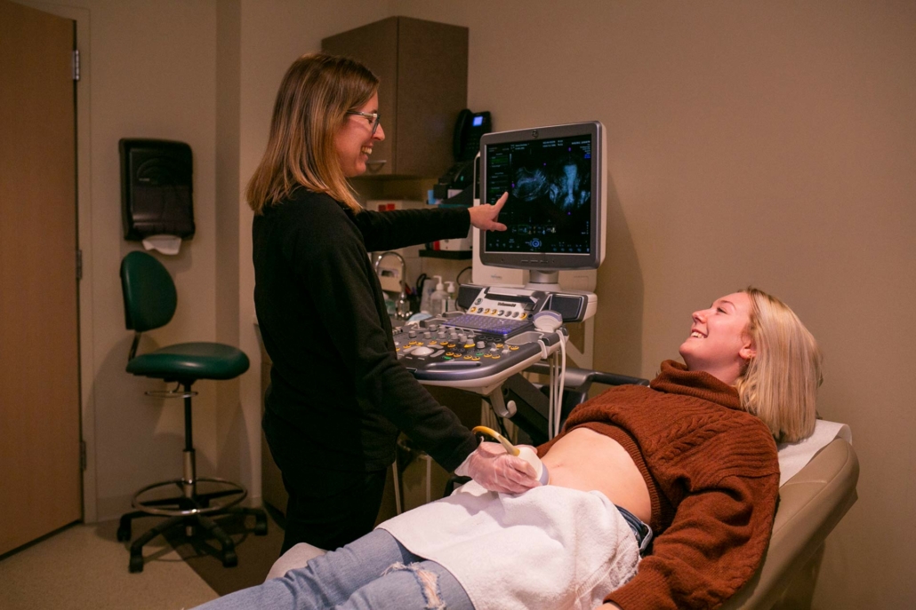 Smiling Madison Women's Health doing an ultrasound on pregnant patient