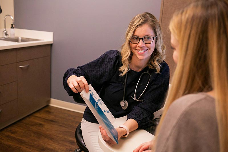 Smiling Madison Women's Health female gynecologist with patient