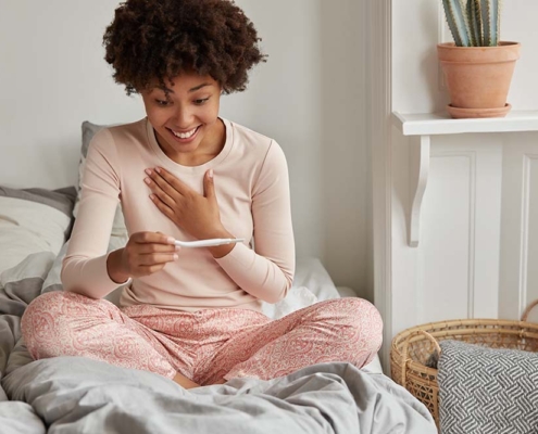 woman happily viewing pregnancy test