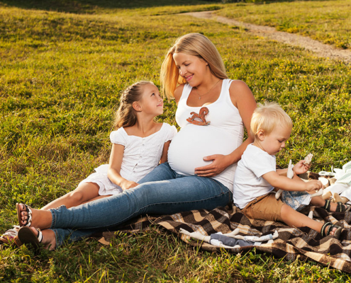 Woman with Polycystic Ovarian Syndrome with two children on blanket