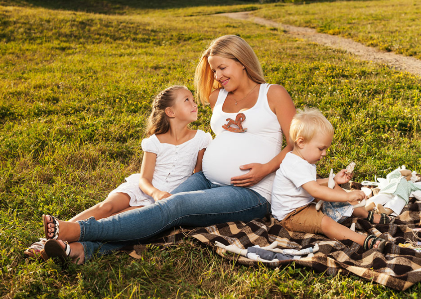 Woman with Polycystic Ovarian Syndrome with two children on blanket