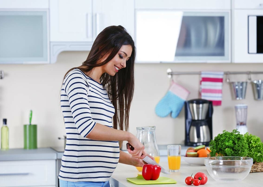 Woman smiling in kitchen who is pregnant after miscarriage